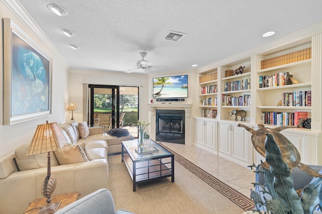 living room with visible vents, a textured ceiling, a fireplace, light tile patterned floors, and ceiling fan