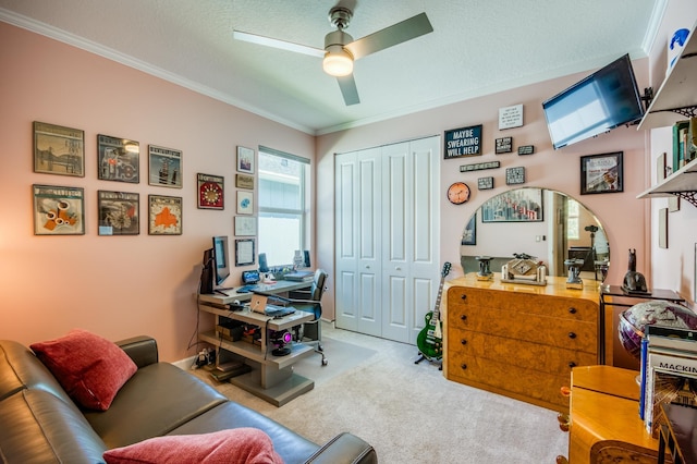 home office with ceiling fan, a textured ceiling, carpet, and crown molding