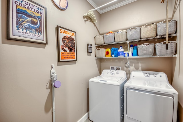 washroom featuring laundry area, washing machine and clothes dryer, and crown molding