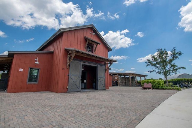 view of outbuilding with a garage, an outbuilding, and decorative driveway