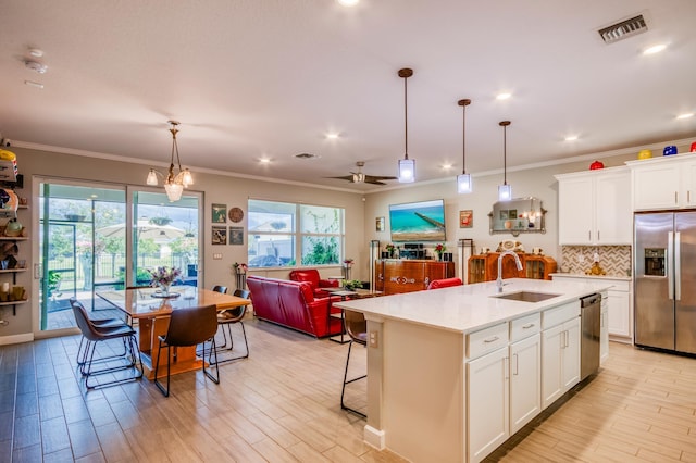 1360 Wandering Willow Way, The Acreage, FL 33470 - kitchen featuring appliances with stainless steel finishes, a sink, plenty of natural light, light countertops, and ornamental molding