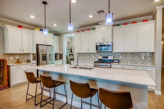 kitchen featuring appliances with stainless steel finishes, white cabinets, visible vents, and a sink