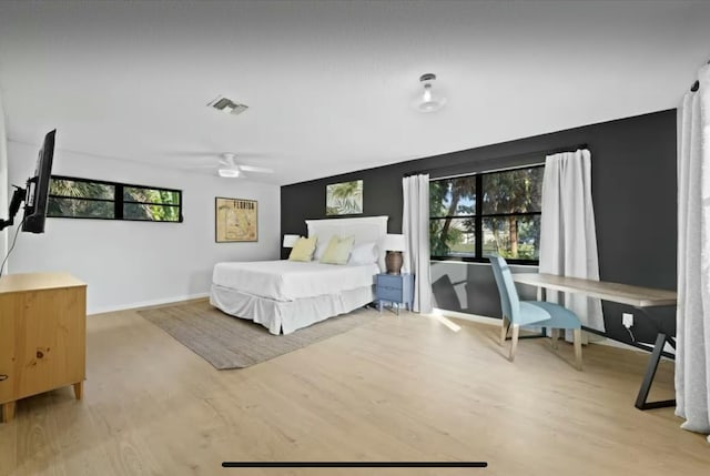 bedroom featuring multiple windows, visible vents, and light wood-style floors