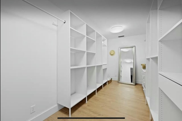 walk in closet with light wood finished floors and visible vents