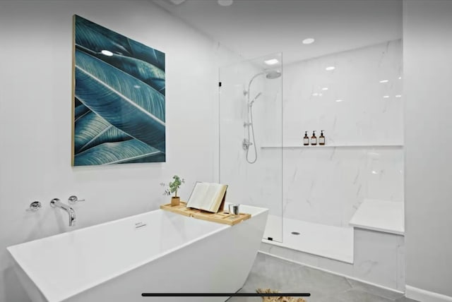 bathroom featuring a freestanding tub and a marble finish shower