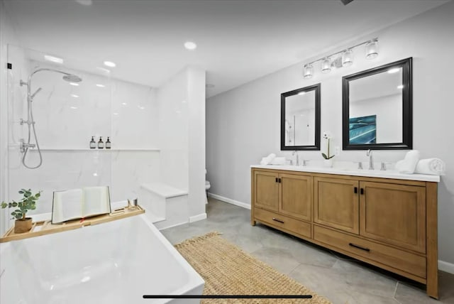 full bath featuring double vanity, walk in shower, a sink, and toilet