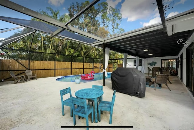 view of patio / terrace featuring glass enclosure, a fenced backyard, a fenced in pool, and area for grilling