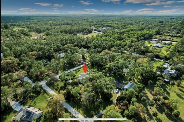 drone / aerial view with a wooded view