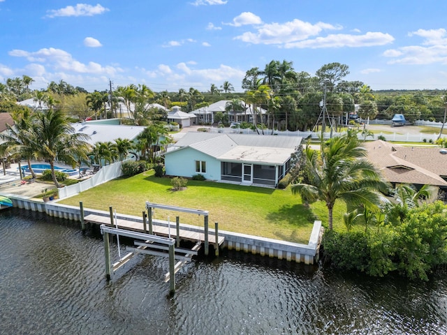 view of dock featuring a yard, fence, a water view, and boat lift