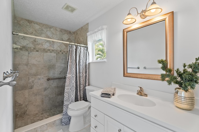 full bath with visible vents, toilet, vanity, tiled shower, and a textured ceiling