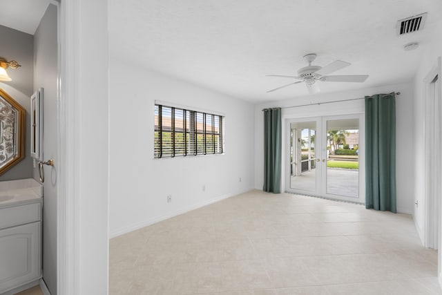 empty room featuring a healthy amount of sunlight, visible vents, french doors, and ceiling fan