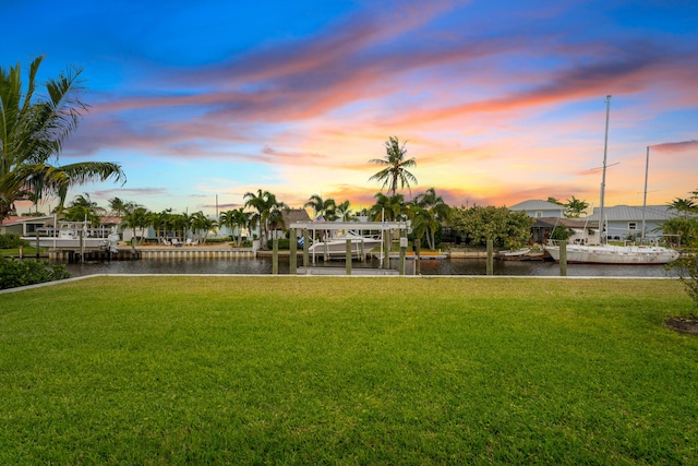 yard at dusk featuring a water view