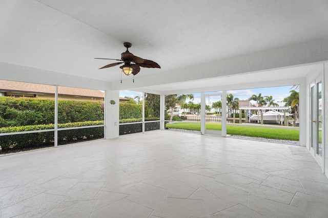 unfurnished sunroom featuring ceiling fan