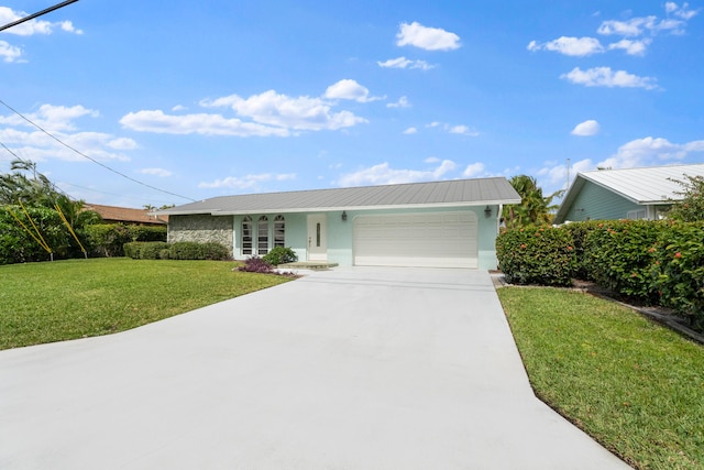 single story home with stucco siding, a front lawn, concrete driveway, an attached garage, and metal roof