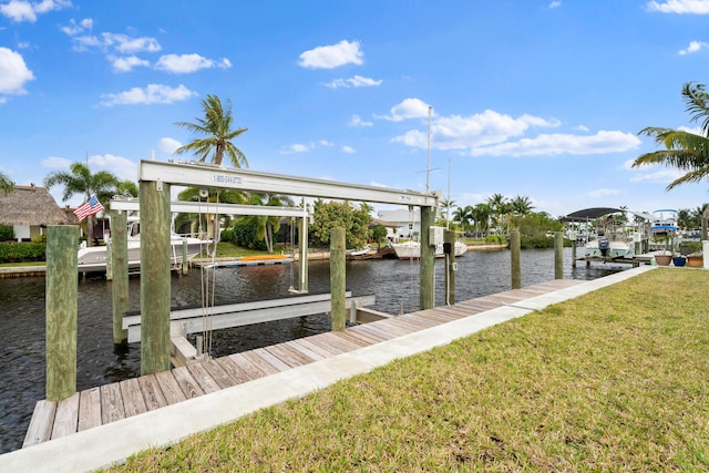 view of dock featuring a lawn, a water view, and boat lift