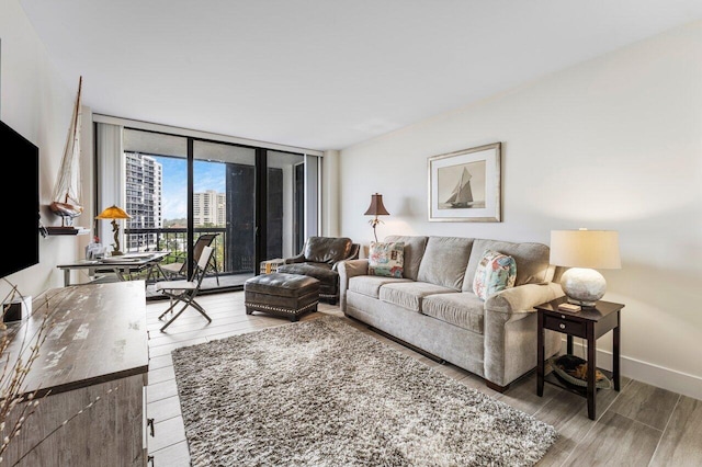 living room with floor to ceiling windows, baseboards, and wood finished floors