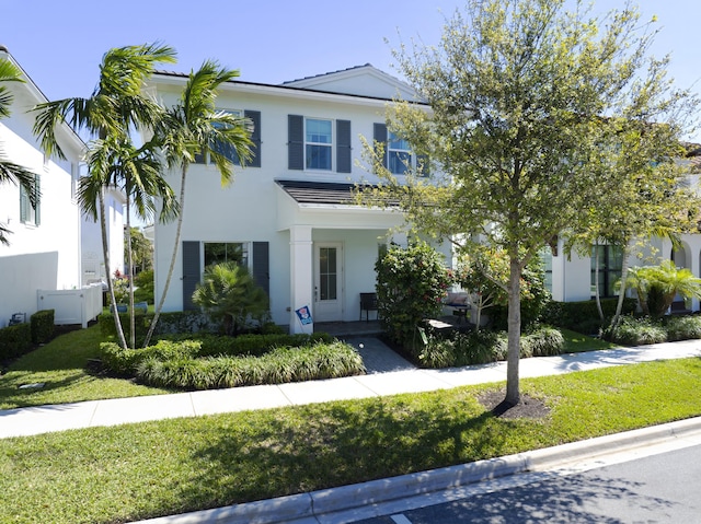 view of front of home with a porch, a front yard, and stucco siding