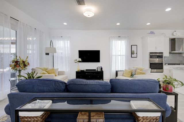 living room with wood finished floors, visible vents, and recessed lighting