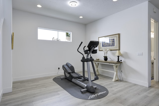 workout room featuring recessed lighting, a textured ceiling, baseboards, and wood finished floors