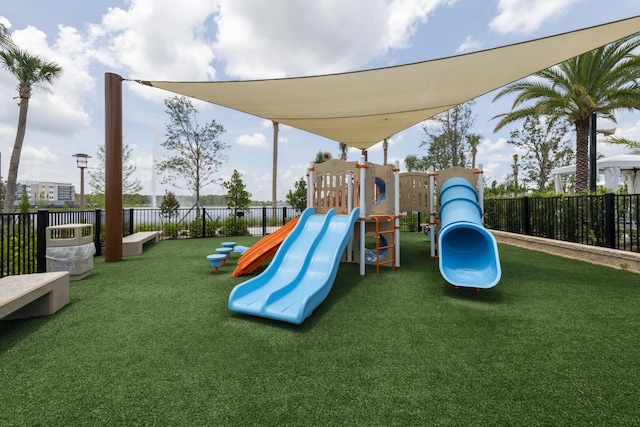 community play area featuring a lawn and fence