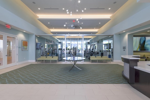 workout area featuring recessed lighting, baseboards, a raised ceiling, and french doors