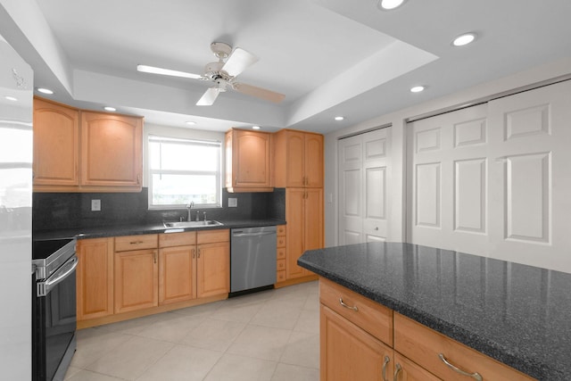 kitchen featuring a tray ceiling, a sink, a ceiling fan, tasteful backsplash, and stainless steel appliances