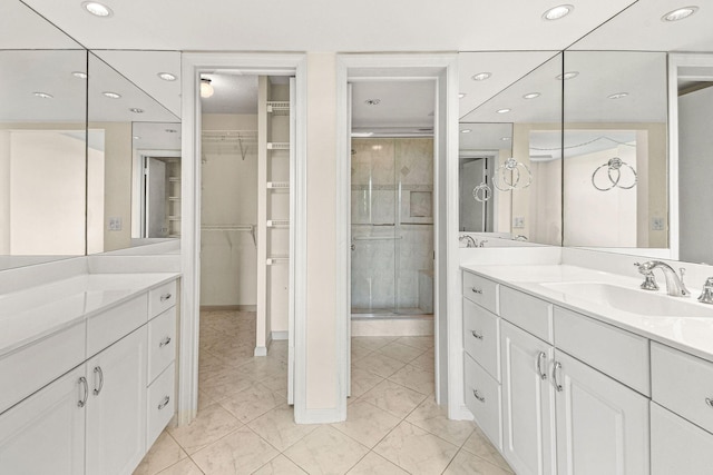 bathroom featuring a spacious closet, vanity, walk in shower, and recessed lighting