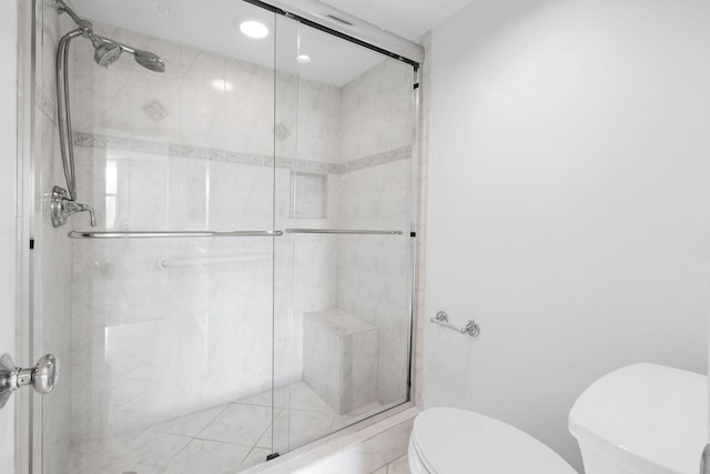full bath with toilet and a stall shower