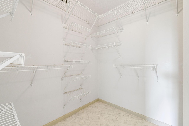 walk in closet with marble finish floor