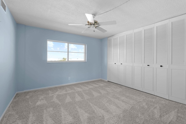 unfurnished bedroom with baseboards, a ceiling fan, carpet floors, and a textured ceiling