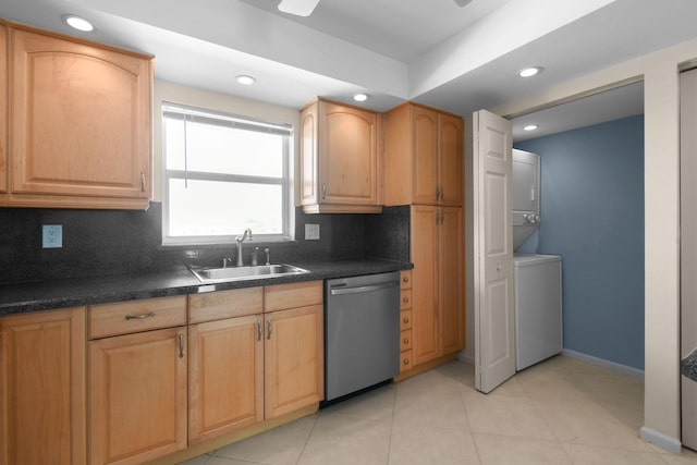 kitchen featuring dishwasher, dark countertops, a sink, stacked washing maching and dryer, and backsplash