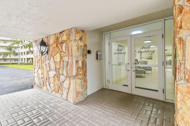 property entrance featuring french doors and stucco siding