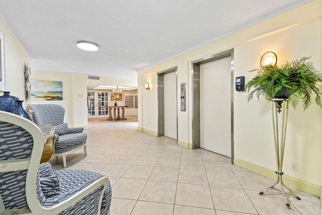 hall with elevator, visible vents, ornamental molding, and light tile patterned floors
