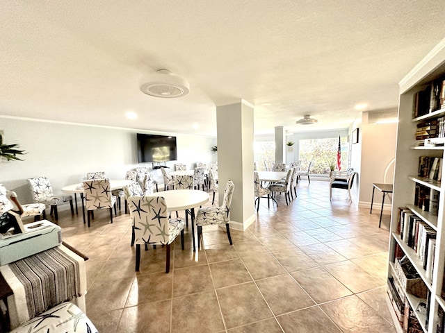 tiled dining space featuring baseboards and a textured ceiling