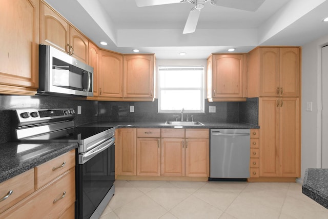 kitchen with light brown cabinets, a sink, tasteful backsplash, and appliances with stainless steel finishes
