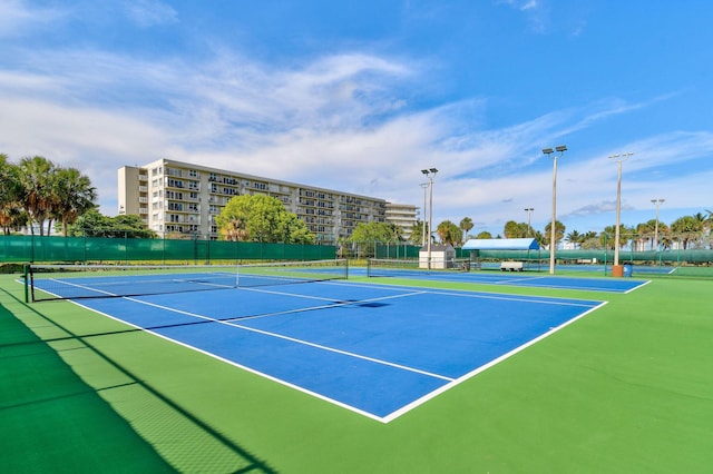 view of tennis court with community basketball court and fence