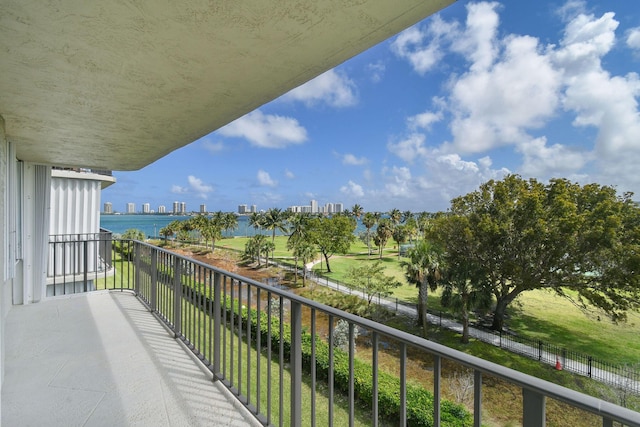 balcony with a water view and a view of city