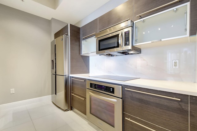 kitchen with dark brown cabinetry, modern cabinets, appliances with stainless steel finishes, and backsplash