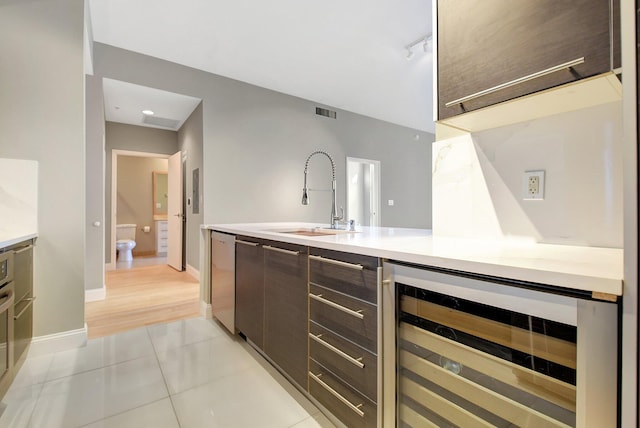 interior space featuring wine cooler, light tile patterned floors, visible vents, a sink, and dishwasher