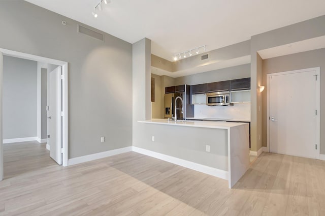 kitchen with stainless steel appliances, light countertops, visible vents, and light wood-style floors