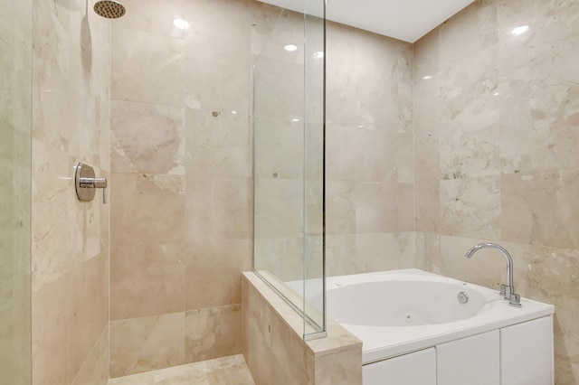 bathroom featuring a bath, tile walls, and tiled shower