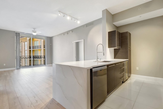 kitchen featuring stainless steel dishwasher, modern cabinets, a sink, and visible vents