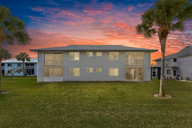 218 SE Village Dr Unit 218, Port Saint Lucie, FL 34952 - rear view of property featuring a lawn, metal roof, cooling unit, and a sunroom
