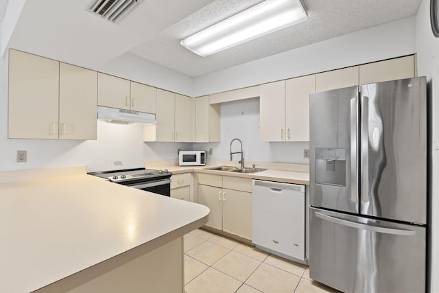 218 SE Village Dr Unit 218, Port Saint Lucie, FL 34952 - kitchen featuring appliances with stainless steel finishes, under cabinet range hood, a sink, light countertops, and light tile patterned floors