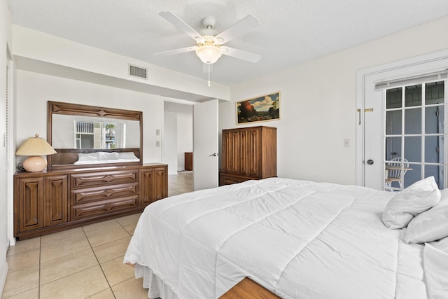 218 SE Village Dr Unit 218, Port Saint Lucie, FL 34952 - bedroom with light tile patterned flooring, access to exterior, a ceiling fan, and a textured ceiling