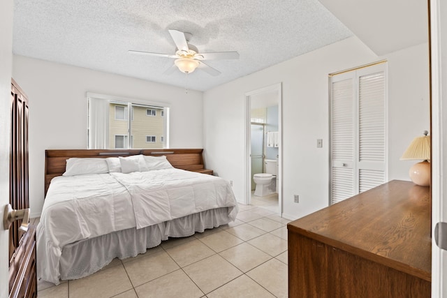 218 SE Village Dr Unit 218, Port Saint Lucie, FL 34952 - bedroom with light tile patterned floors, a textured ceiling, a closet, ensuite bath, and a ceiling fan