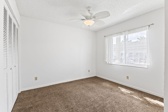 218 SE Village Dr Unit 218, Port Saint Lucie, FL 34952 - unfurnished bedroom with carpet floors, a textured ceiling, a closet, baseboards, and ceiling fan
