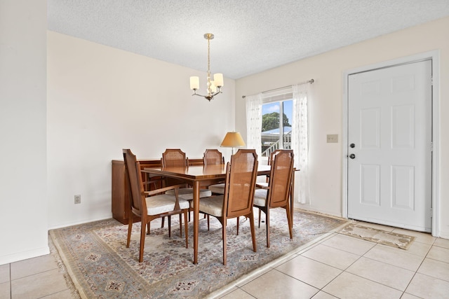 218 SE Village Dr Unit 218, Port Saint Lucie, FL 34952 - dining area featuring a chandelier, light tile patterned floors, a textured ceiling, and baseboards