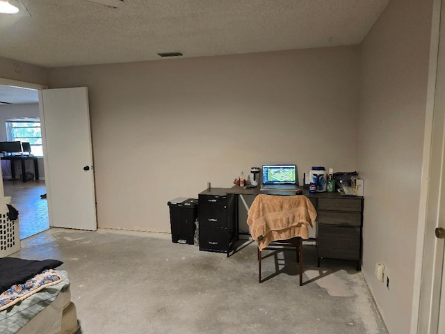 office space with visible vents, unfinished concrete flooring, and a textured ceiling