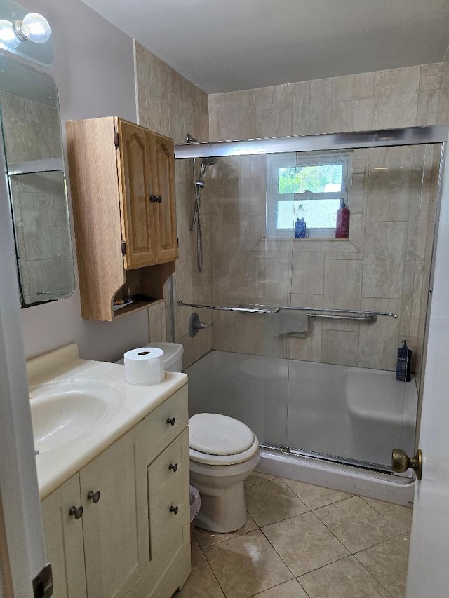 bathroom with a stall shower, tile patterned flooring, vanity, and toilet